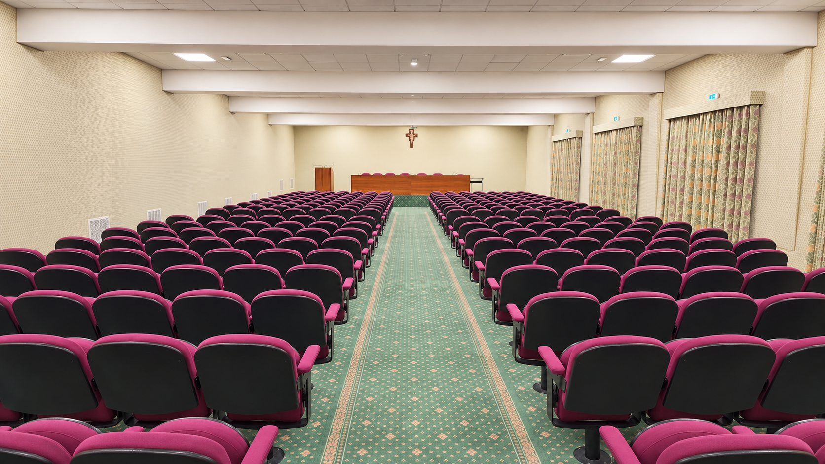 Sala incontri con file di sedute e tavolo dei relatori